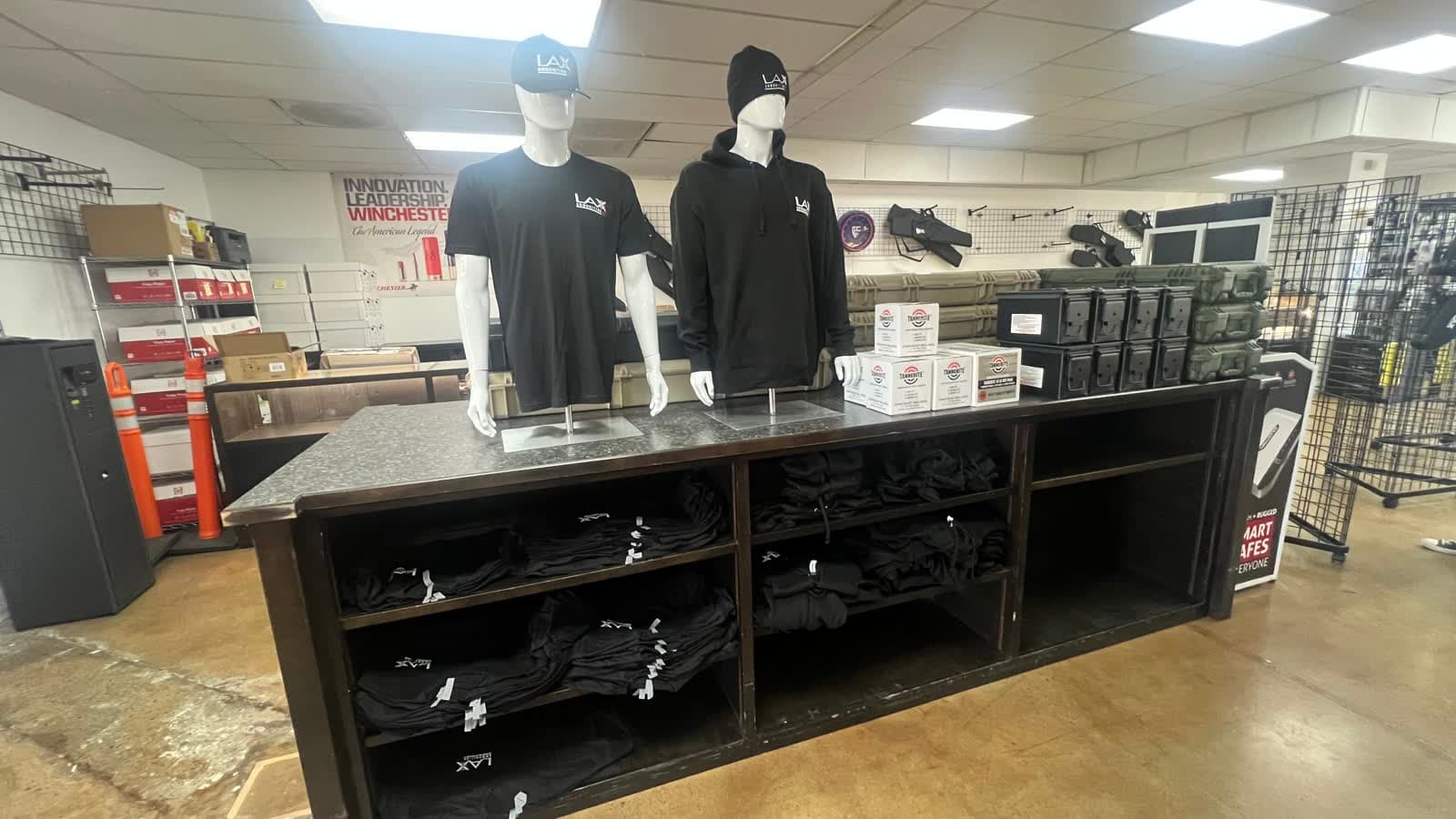 The main aisle at LAX Ammo San Diego, with counters on both sides and apparel toward the back