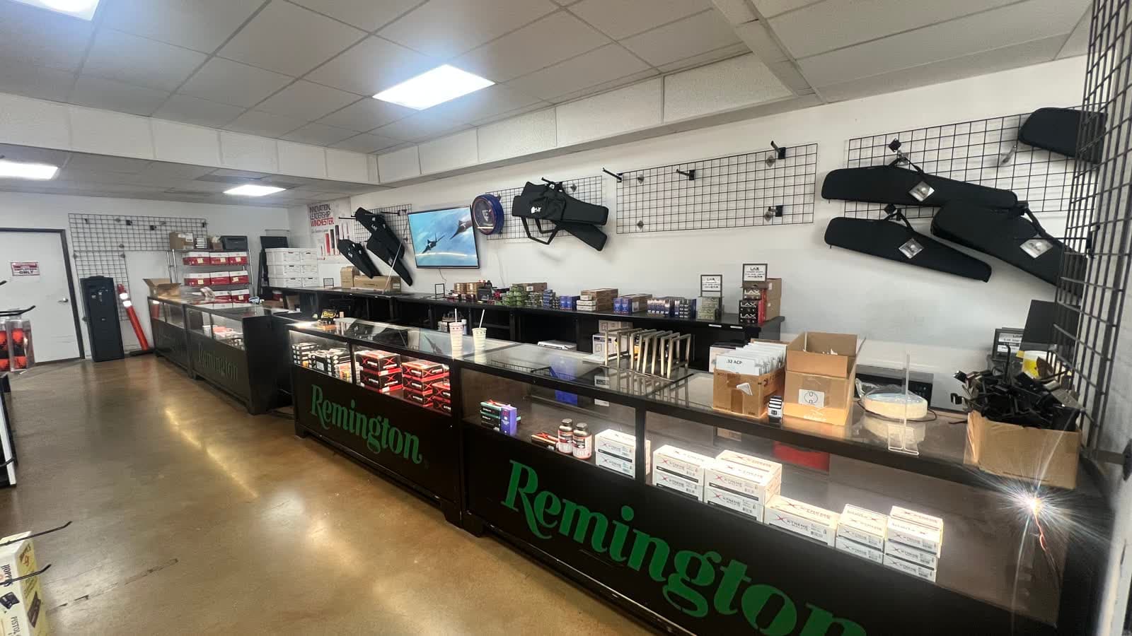 Bulk ammunition boxes and cases stacked along the Remington counters at LAX Ammo San Diego in Kearny Mesa